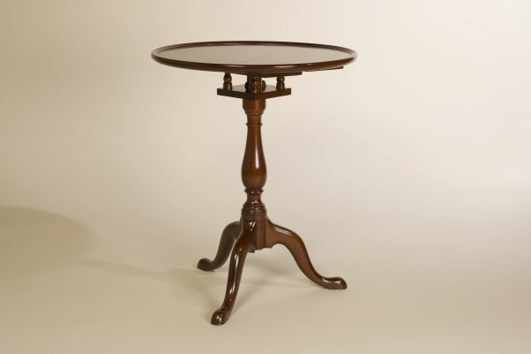 A round wooden side table with a polished surface, supported by a single pedestal and three curved legs.